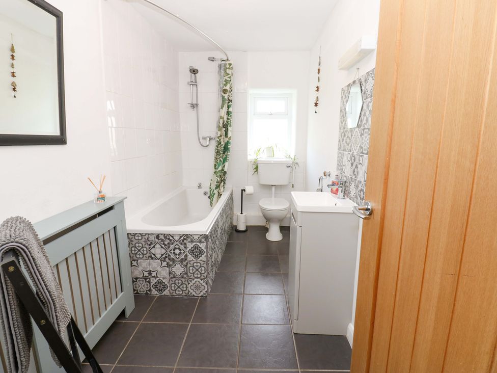 A bathroom with a bath, toilet, and sink at The Hayloft in Ellingstring near Masham