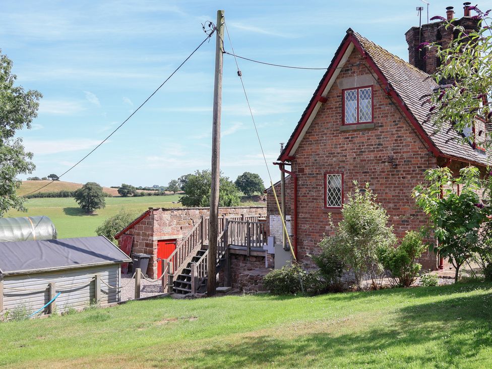 An outdoor view of a house with a garden and steps at 1 Fountain Cottages in Peckforton, Tarporley