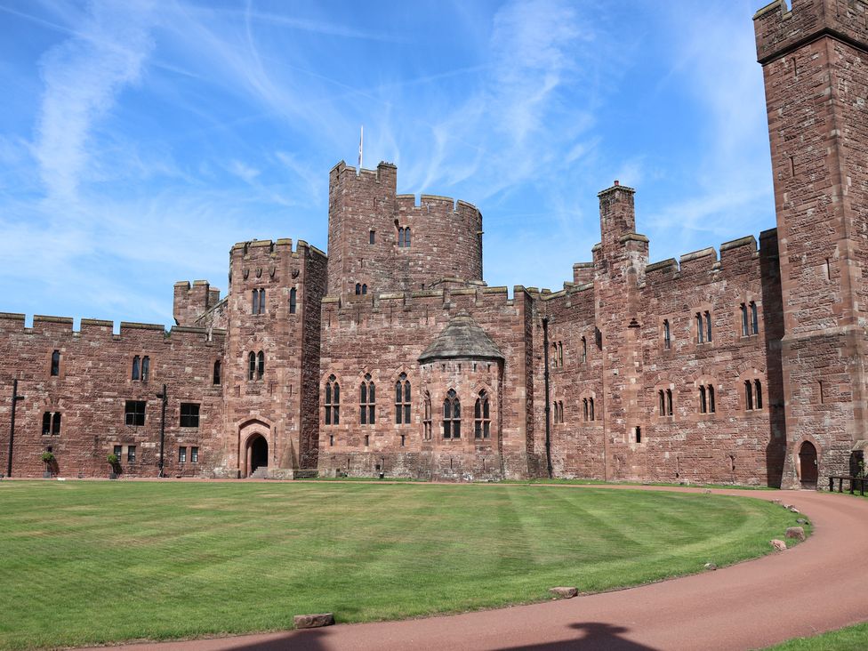 A castle with towers and a courtyard at 1 Fountain Cottages in Peckforton, Tarporley