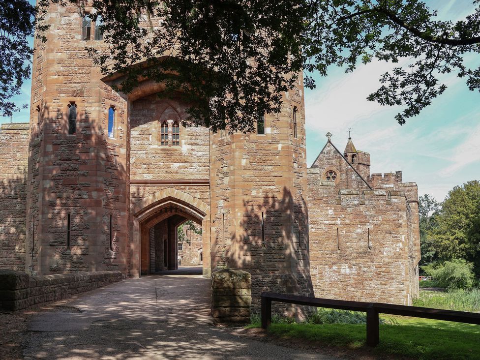 A castle with towers and archways at 1 Fountain Cottages in Peckforton, Tarporley