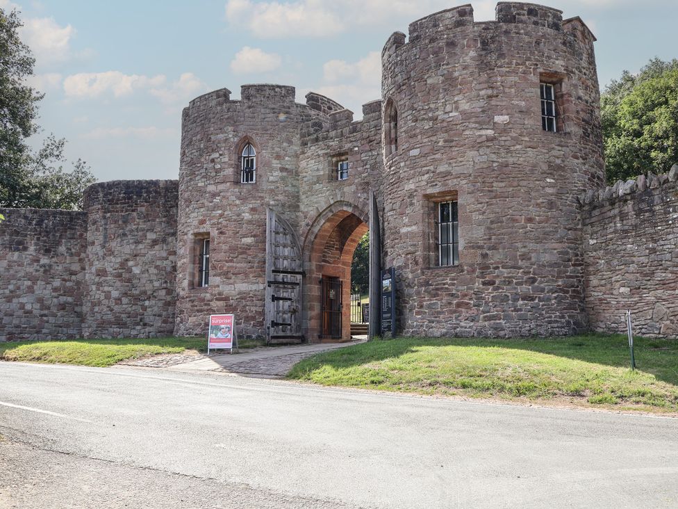 A castle entrance with walls and a gate at 1 Fountain Cottages in Peckforton, Tarporley