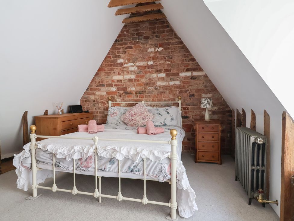 A bedroom with a bed and dresser at 1 Fountain Cottages in Peckforton, Tarporley