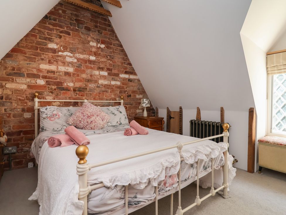 A bedroom with a bed and a window at 1 Fountain Cottages in Peckforton, Tarporley