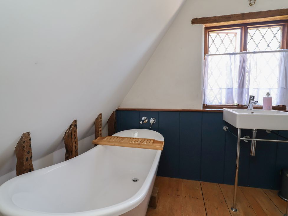 A bathroom with a bathtub and sink at 1 Fountain Cottages Peckforton Tarporley