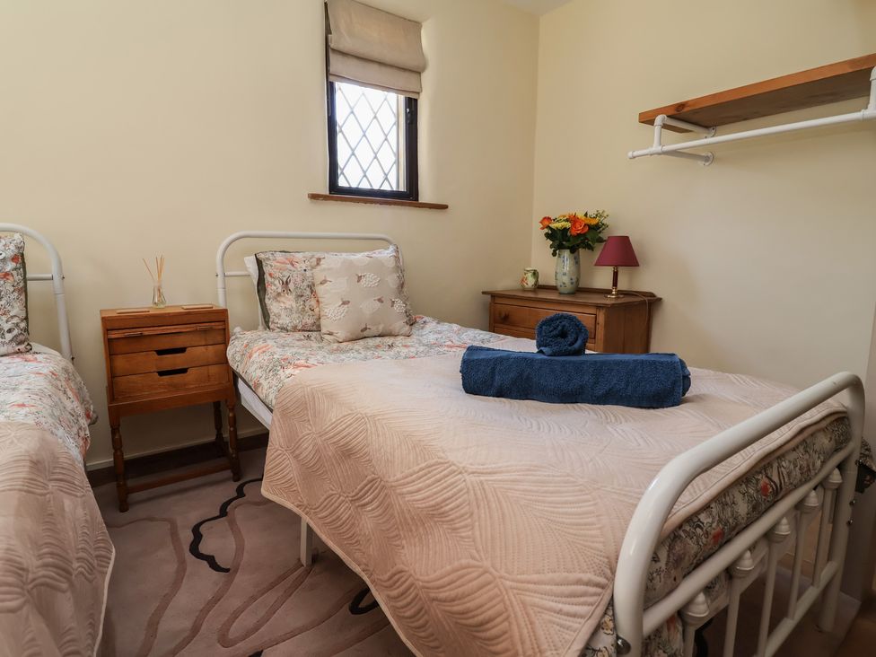 A bedroom with two beds and a wooden drawer at 1 Fountain Cottages in Peckforton, Tarporley