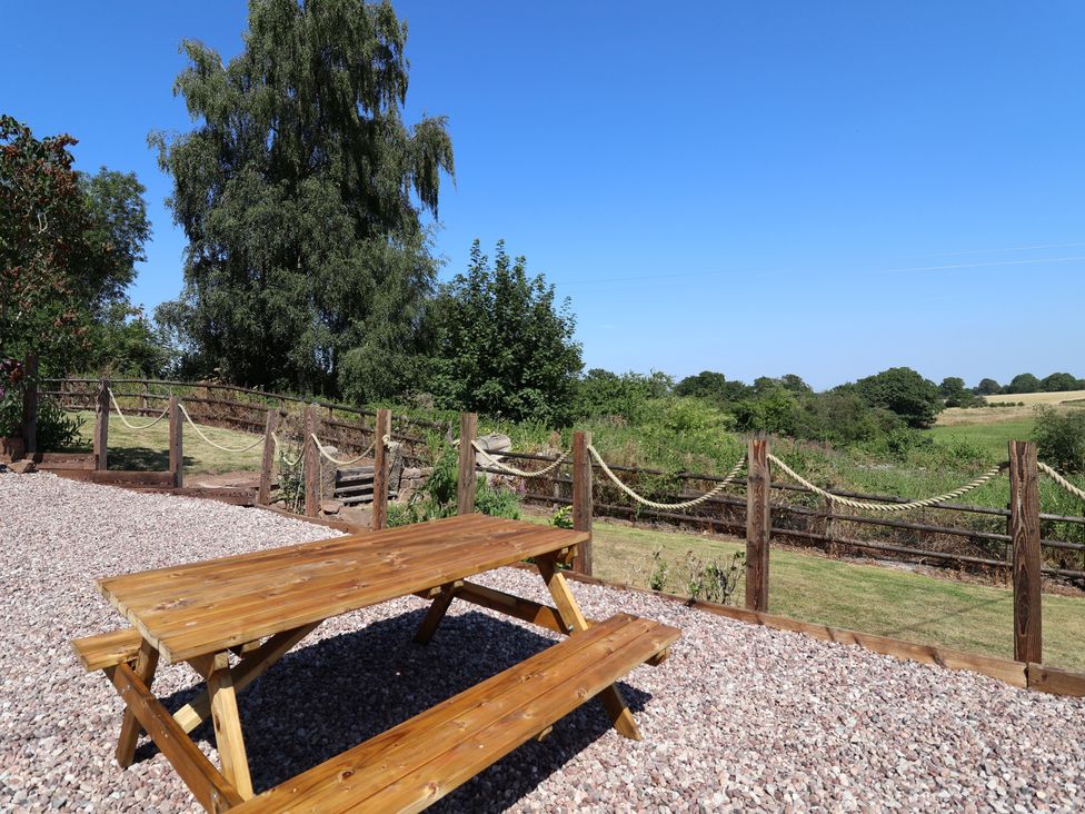 A picnic table with surrounding nature at 1 Fountain Cottages in Peckforton, Tarporley