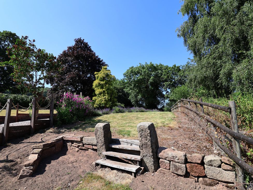 A garden with steps and trees at 1 Fountain Cottages in Peckforton, Tarporley