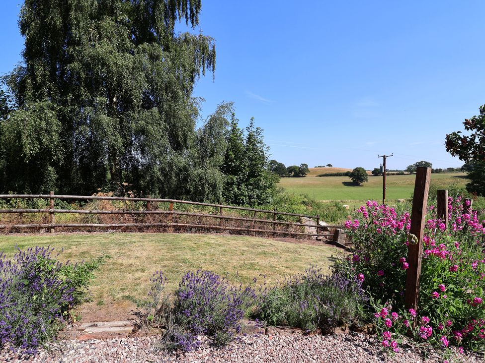 A garden with flowers and a scenic view at 1 Fountain Cottages in Peckforton, Tarporley