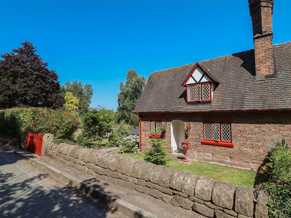 A house with a garden and stone wall at 1 Fountain Cottages in Peckforton, Tarporley