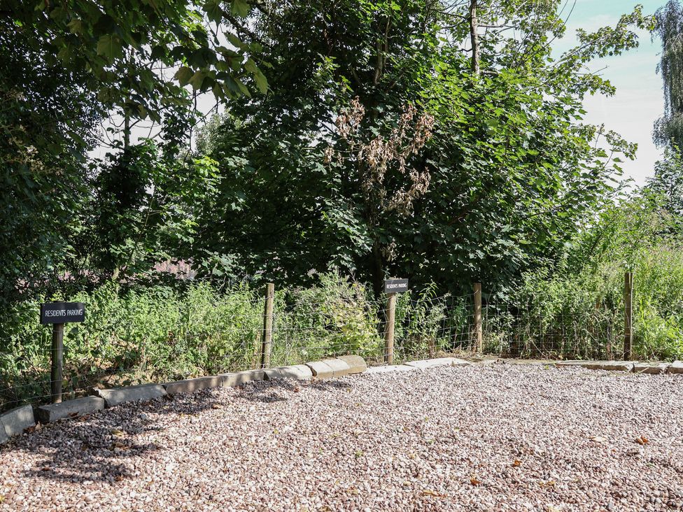 An outdoor parking area with signs at 1 Fountain Cottages in Peckforton, Tarporley