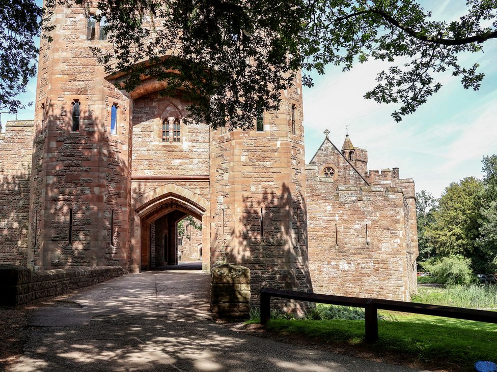 An entrance to a castle with a pathway at 1 Fountain Cottages in Peckforton, Tarporley