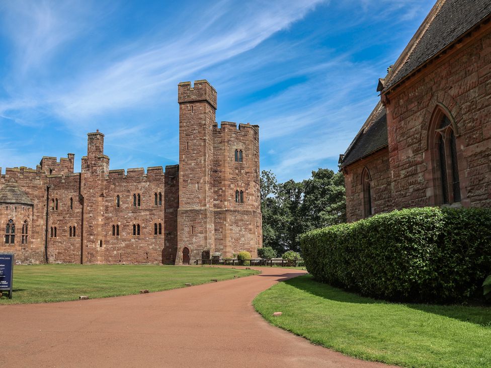 A castle with towers and a pathway at 1 Fountain Cottages, Peckforton, Tarporley