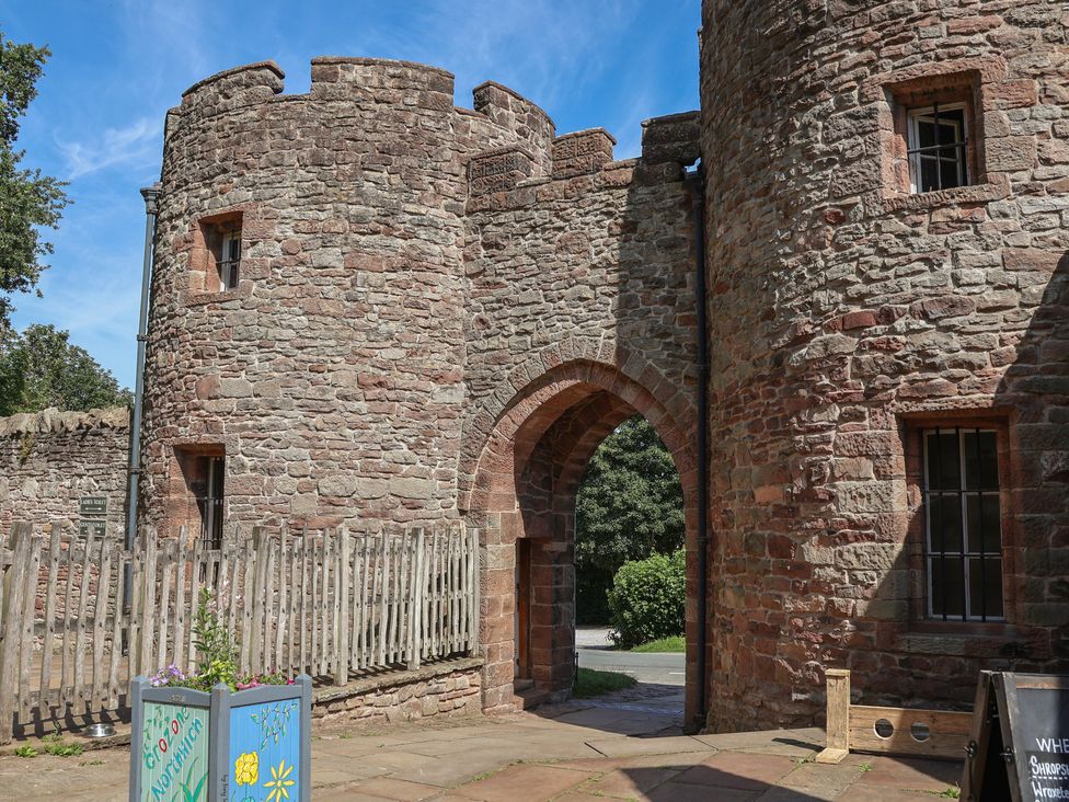 A stone wall with archway and windows at 1 Fountain Cottages Peckforton, Tarporley