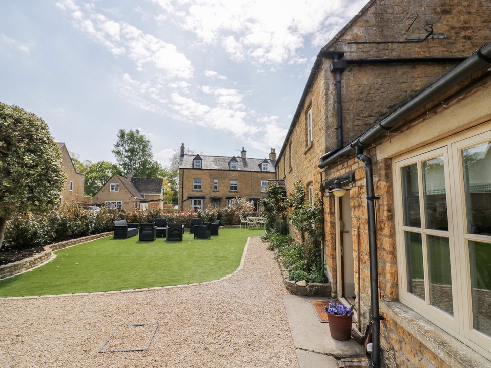 A garden with seating and grass area at Robins Nest Bourton-On-The-Water
