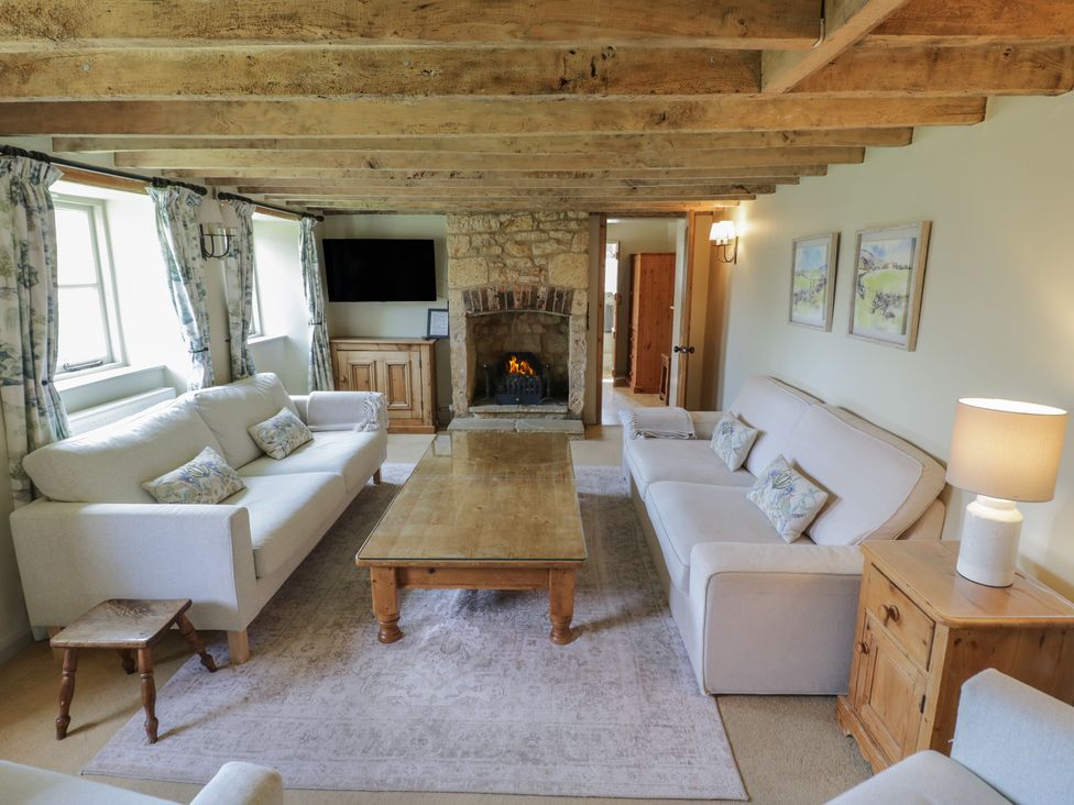 A living room with sofas and a fireplace at Robins Nest in Bourton-On-The-Water
