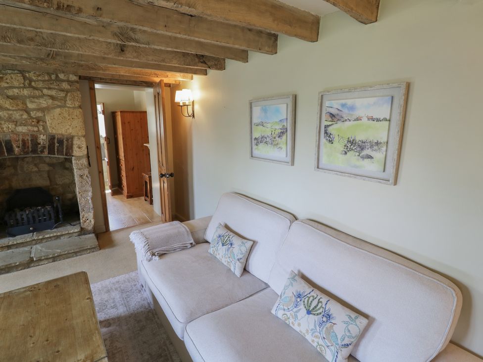 A living room with a sofa and fireplace at Robins Nest in Bourton-On-The-Water