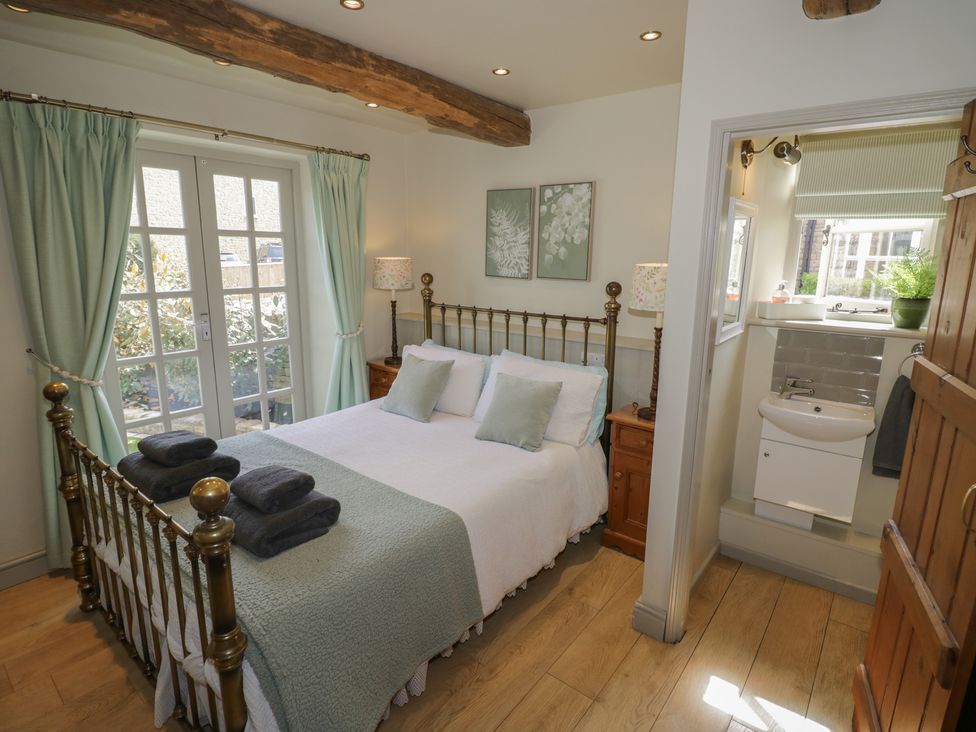 A bedroom with a bed and connecting bathroom at Robins Nest in Bourton-On-The-Water