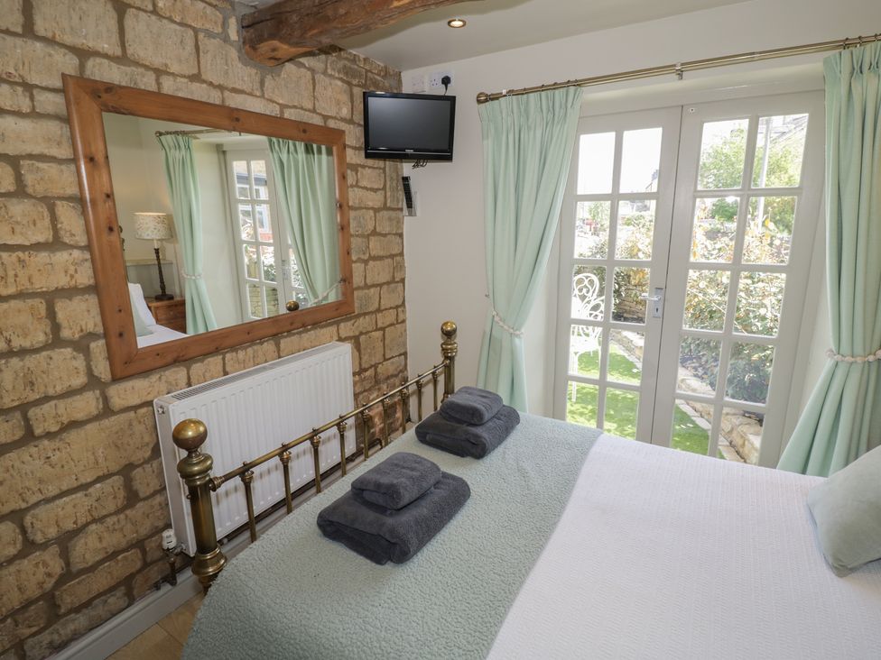 A bedroom with a bed and television at Robins Nest in Bourton-On-The-Water