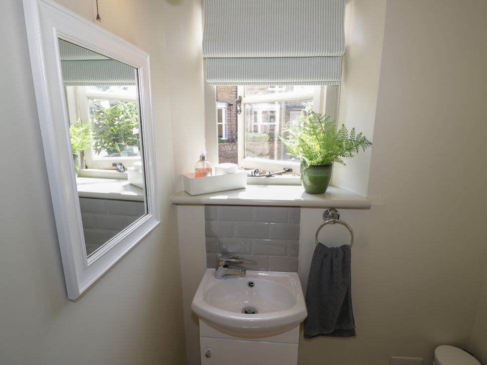 A bathroom with a sink and mirror at Robins Nest Bourton-On-The-Water
