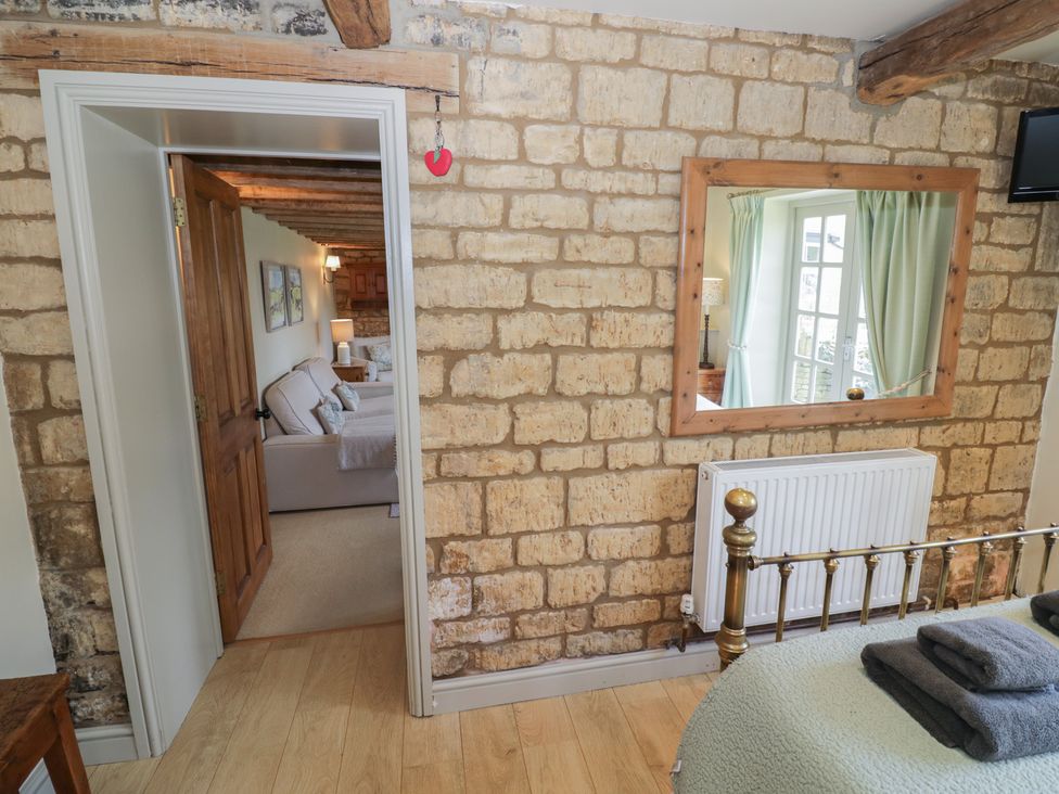 A bedroom with a door and window at Robins Nest in Bourton-On-The-Water