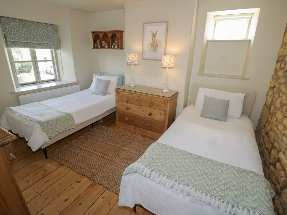 A bedroom with two beds and a dresser at Robins Nest in Bourton-On-The-Water