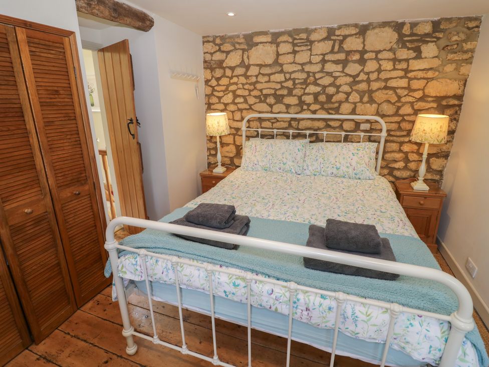A bedroom with a bed and wooden furniture at Robins Nest in Bourton-On-The-Water