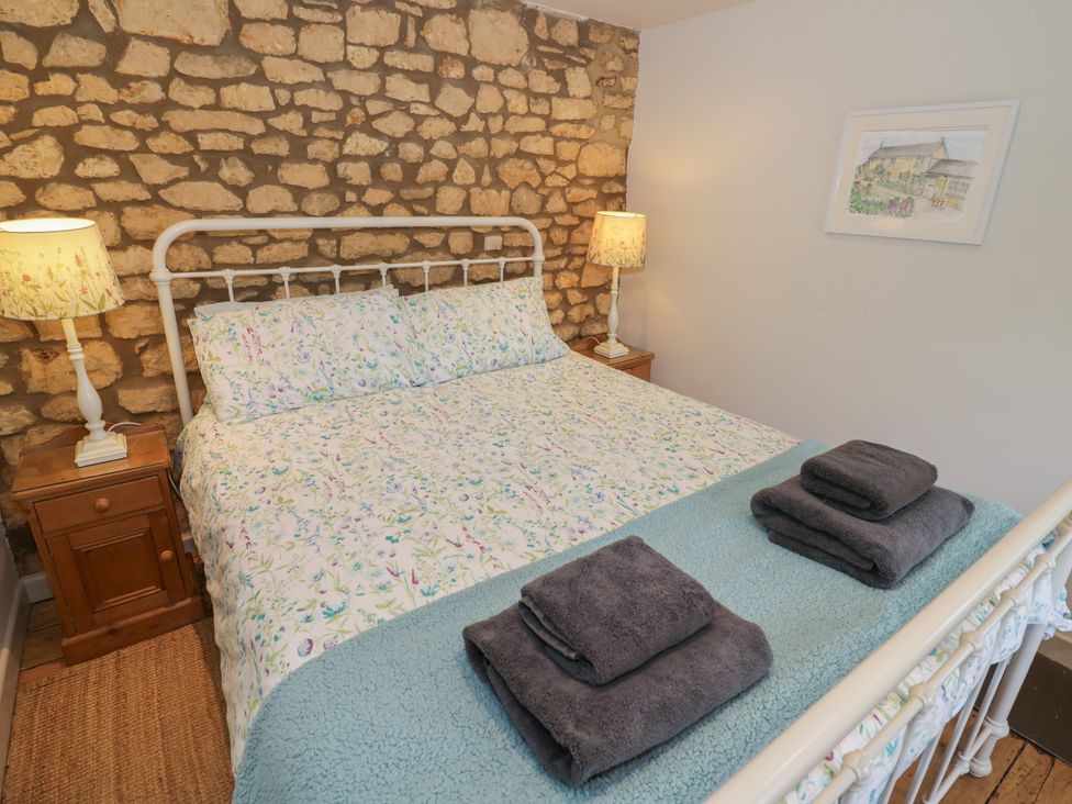 A bedroom with a bed and bedside table at Robins Nest Bourton-On-The-Water
