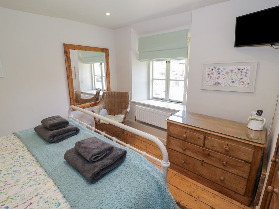 A bedroom with a bed and towels folded on it at Robins Nest in Bourton-On-The-Water