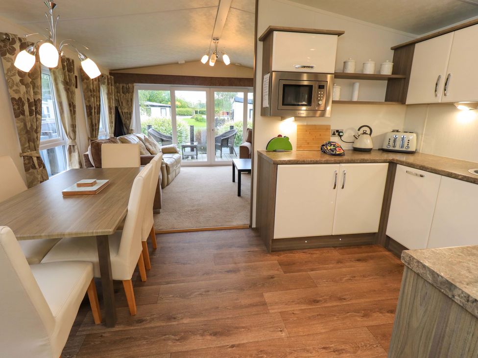 A kitchen and dining area with appliances and furniture at 41, Grandma's Cottage South Lakeland Leisure Village near Carnforth