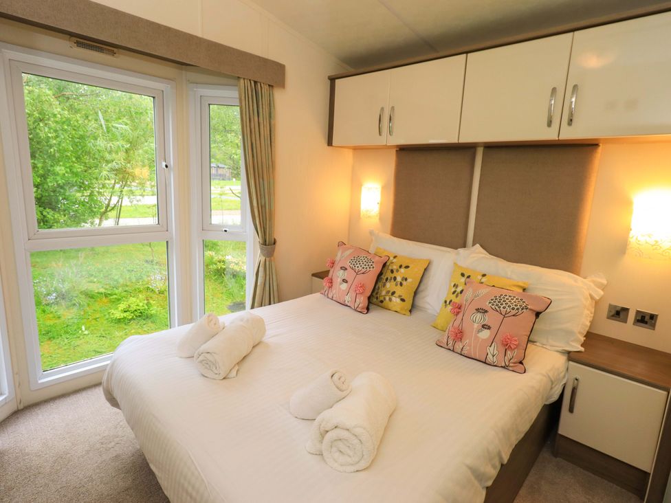 A bedroom with a bed and windows at 41, Grandma's Cottage South Lakeland Leisure Village near Carnforth