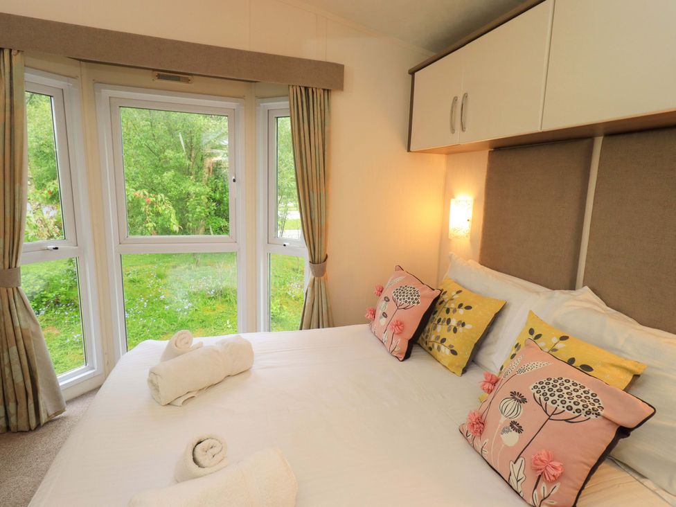 A bedroom with a bed and decorative pillows at 41, Grandma's Cottage South Lakeland Leisure Village near Carnforth