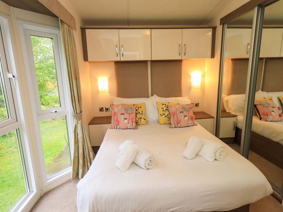 A bedroom with a bed and wardrobe at 41, Grandma's Cottage South Lakeland Leisure Village near Carnforth
