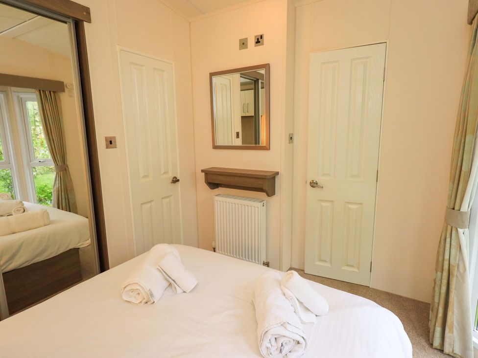 A bedroom with a bed and mirror at 41, Grandma's Cottage South Lakeland Leisure Village near Carnforth