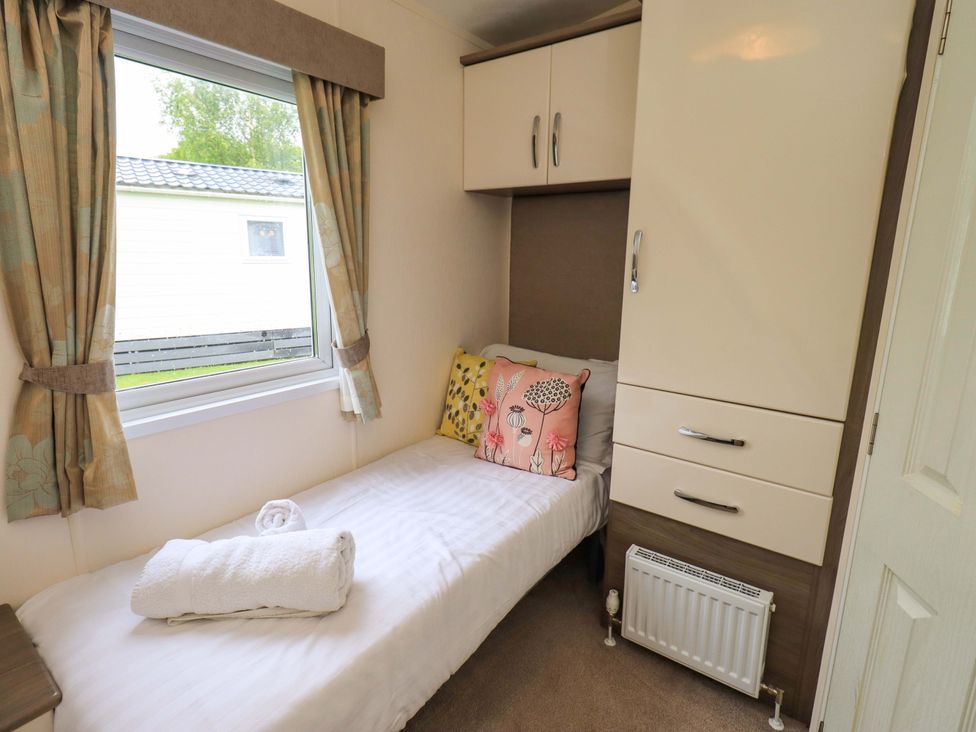 A bedroom with a bed and wardrobe at 41, Grandma's Cottage South Lakeland Leisure Village near Carnforth