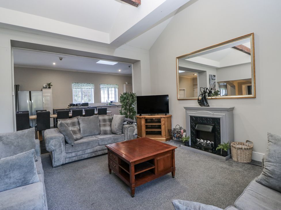 A living room with a sofa, coffee table, and television at Clarence House in Dalton-In-Furness