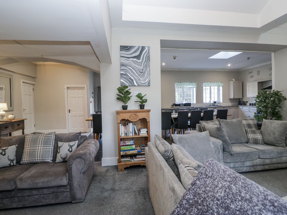 A living room with sofas and a bookshelf at Clarence House in Dalton-In-Furness