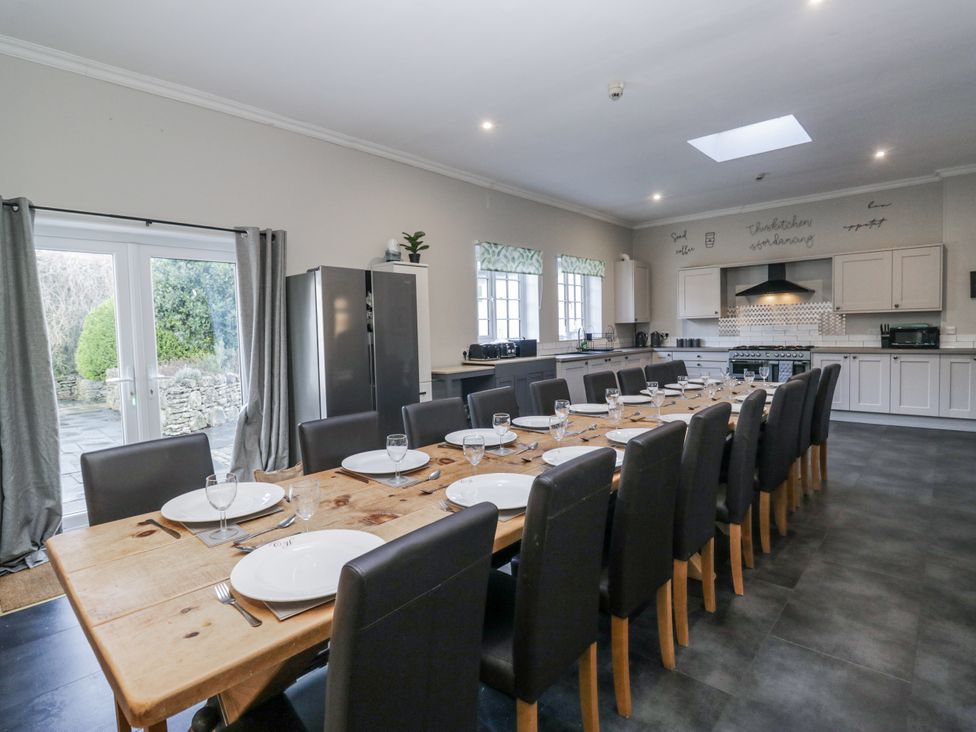 A kitchen with a large dining table and appliances at Clarence House in Dalton-In-Furness