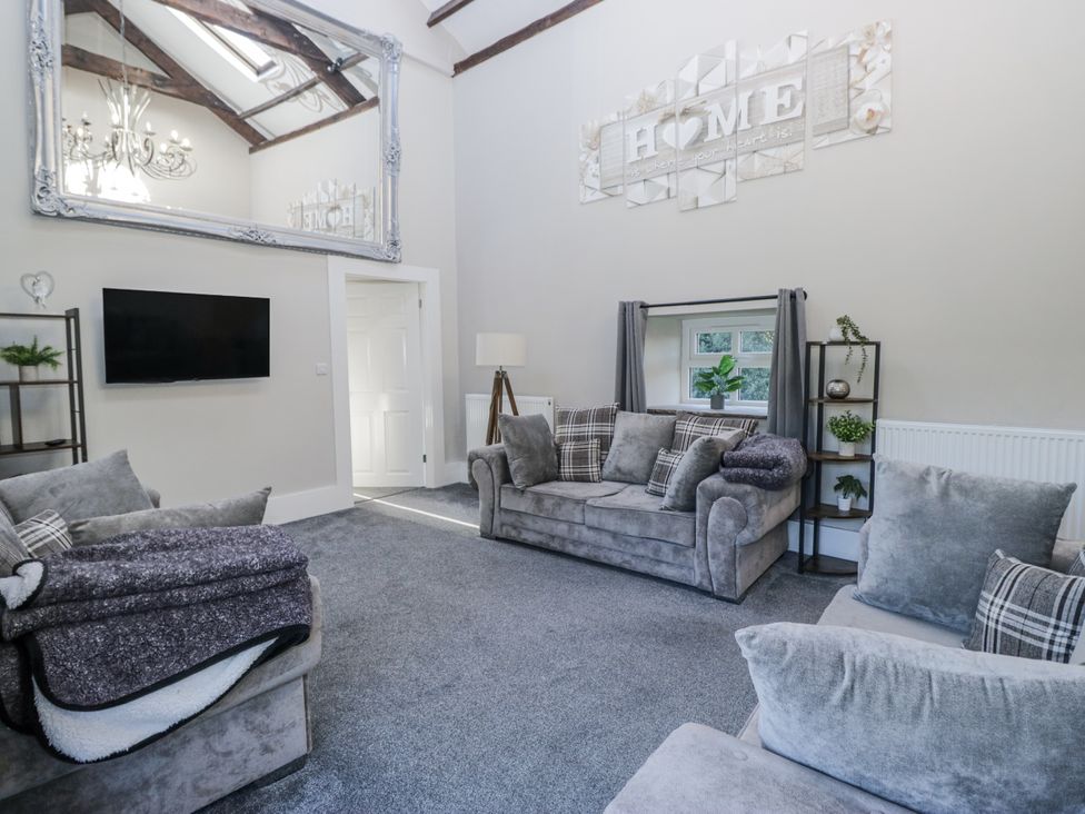 A living room with a sofa and television at Clarence House in Dalton-In-Furness