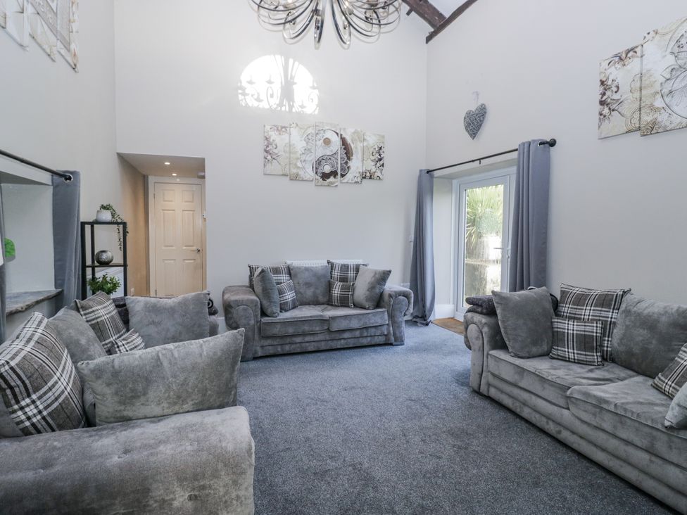 A living room with sofas and wall art at Clarence House in Dalton-In-Furness