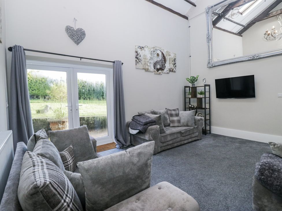 A living room with a sofa and television at Clarence House in Dalton-In-Furness