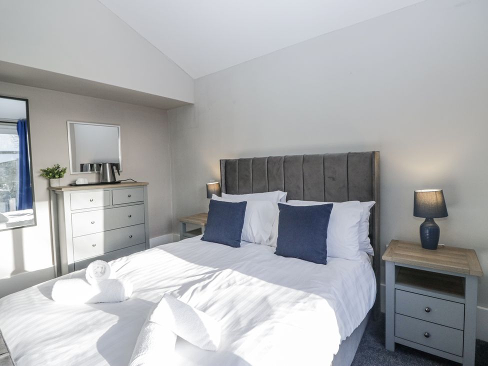 A bedroom with a bed, bedside tables and lamps at Clarence House in Dalton-In-Furness