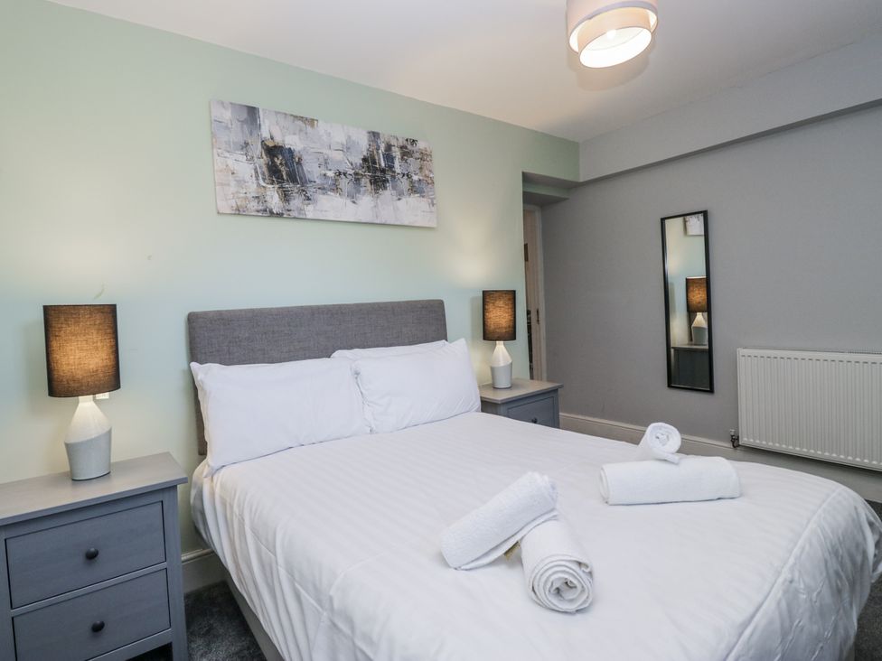 A bedroom with a bed and lamps on nightstands at Clarence House in Dalton-In-Furness