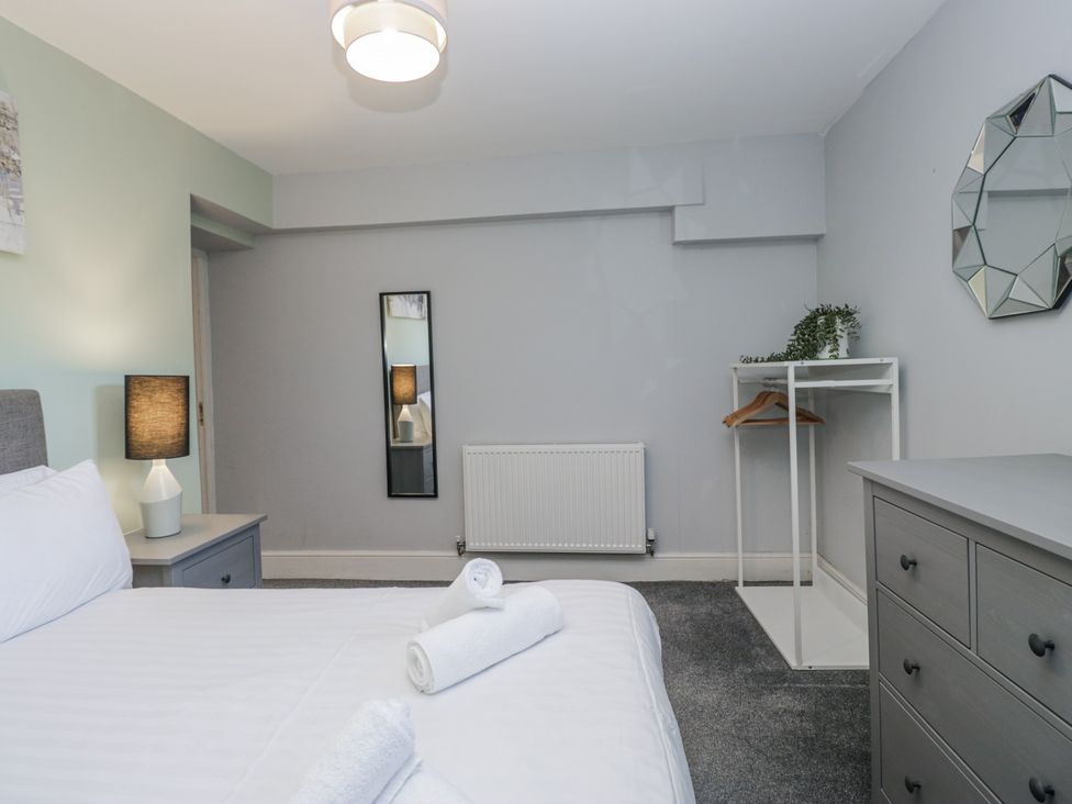 A bedroom with a bed and a mirror at Clarence House in Dalton-In-Furness