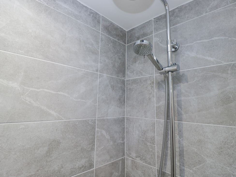 A shower with wall tiles at Clarence House in Dalton-In-Furness