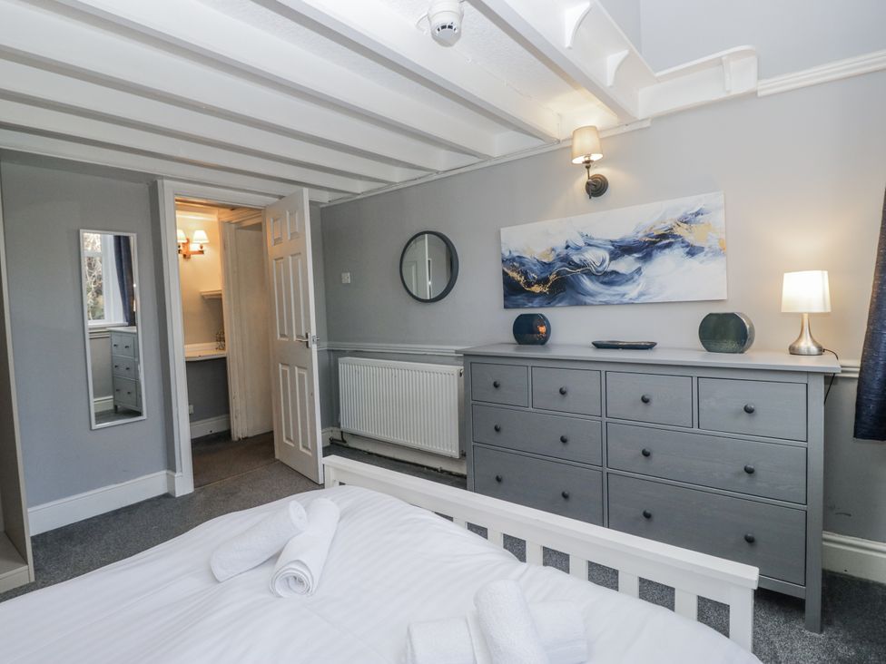 A bedroom with a bed and dresser at Clarence House in Dalton-In-Furness