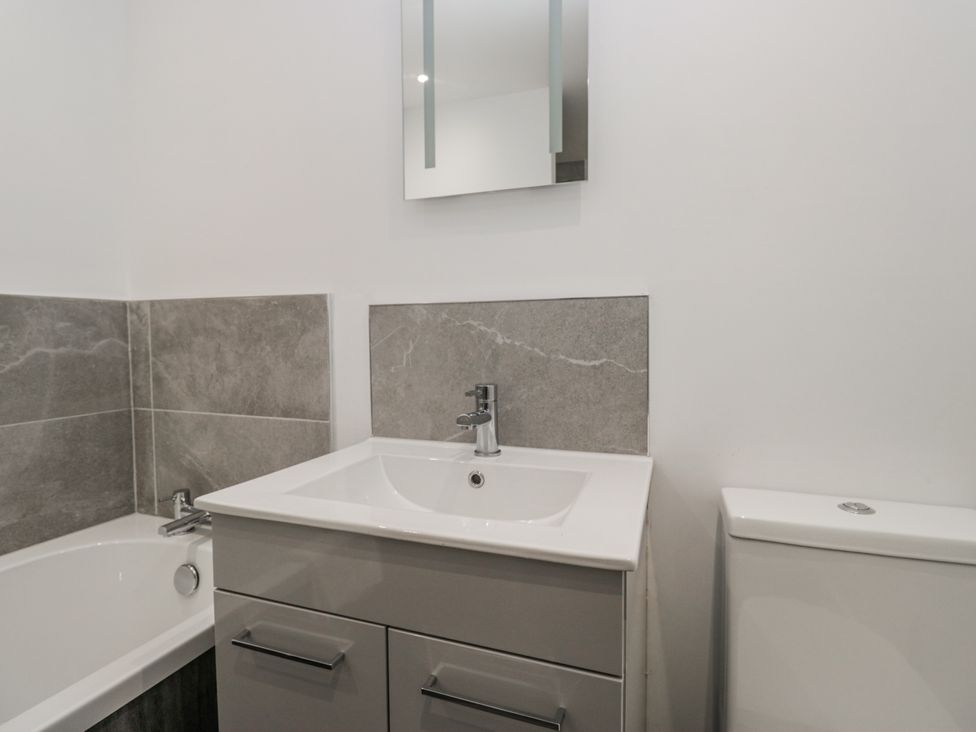 A bathroom with a bathtub and sink at Clarence House Dalton-In-Furness