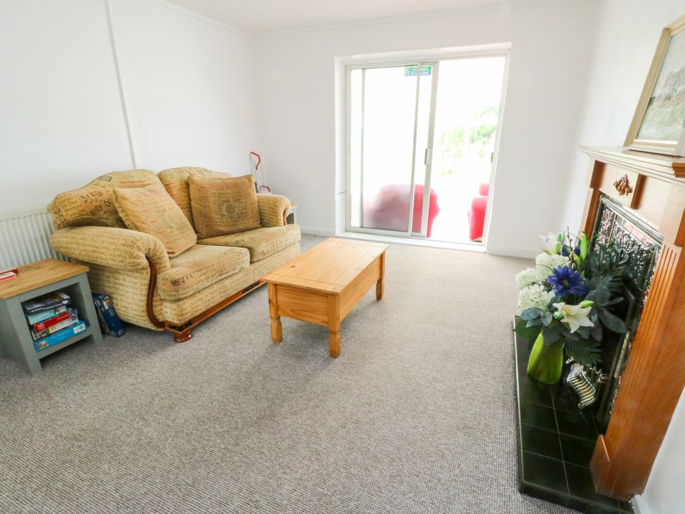 A living room with a sofa, coffee table, and fireplace at Pen Bonc Llanddaniel Near Gaerwen