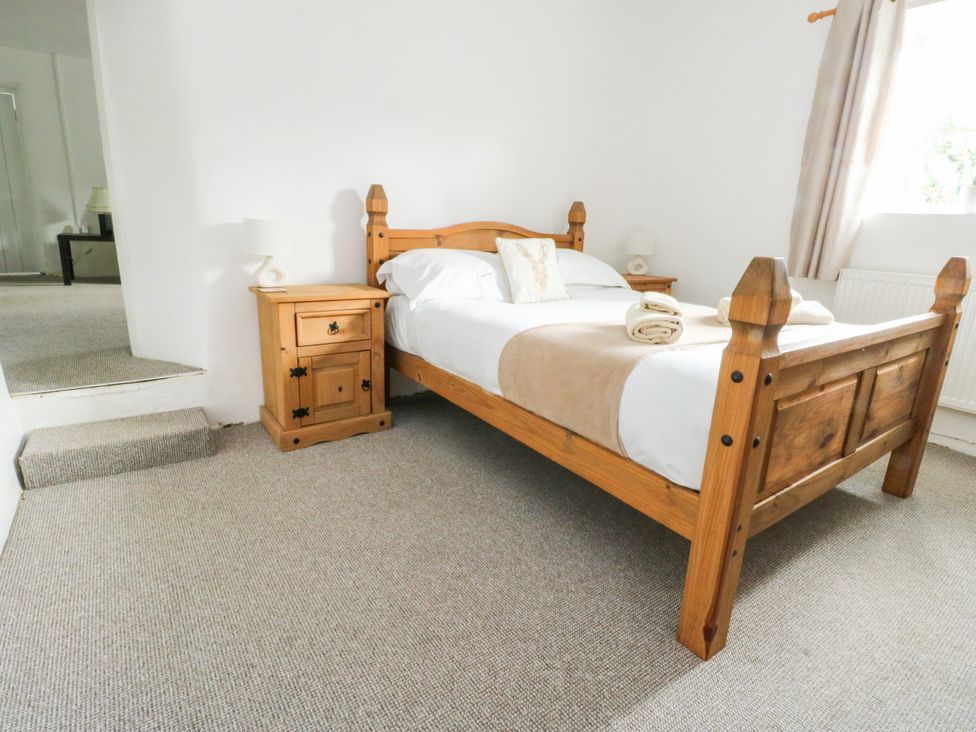 A bedroom with a bed and nightstand at Pen Bonc Llanddaniel Near Gaerwen