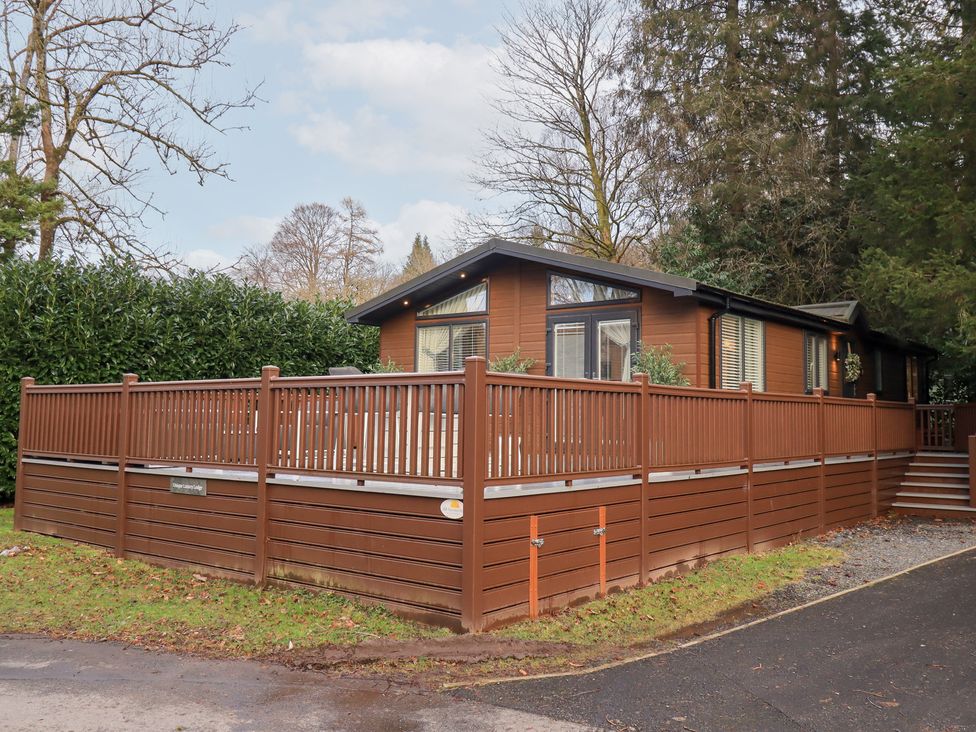 A lodge with a wooden deck and railings at Unique Luxury Lodge 1 Langdale, White Cross Bay near Windermere
