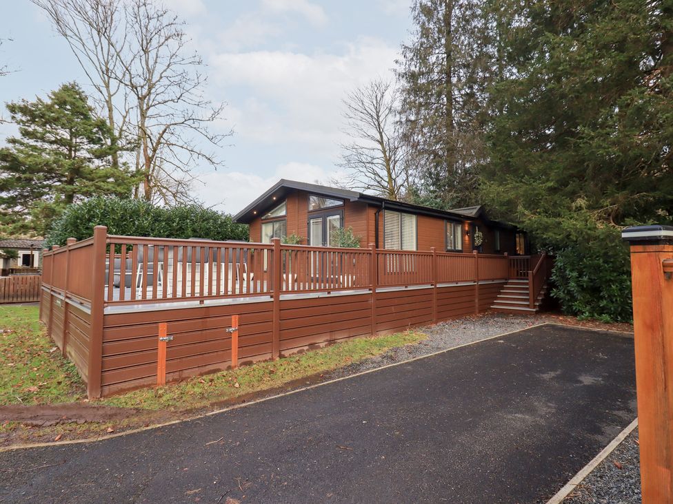 A house with a deck and driveway at Unique Luxury Lodge 1 Langdale, White Cross Bay near Windermere